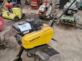 de nombreuses tondeuses à gazon et autres équipements de jardinage dans un garage