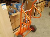 an orange hand truck with a black handle in a warehouse