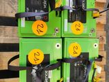 une pile de piles vertes posée sur une palette en bois