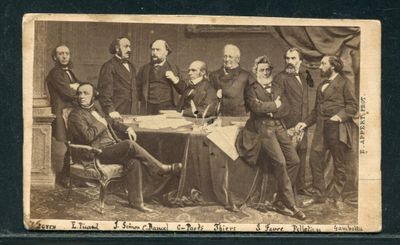 une vieille photo montrant un groupe d'hommes assis autour d'une table
