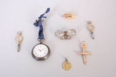 de nombreux breloques et une montre de poche posés sur la table