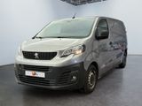 the small van is parked in the large room of the building