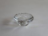 un anneau en verre transparent posé sur une table avec un fond blanc