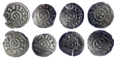 six ancient silver coins with designs on them on a white surface