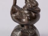 figurine en bronze représentant un oiseau sur un socle, sur fond blanc
