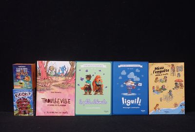 plusieurs livres pour enfants alignés sur une surface noire