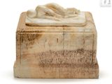 a marble box with a statue of a woman laying on it