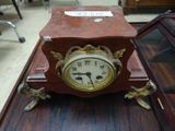 a small clock sitting on top of a wooden table