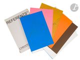 four different colored notebooks sitting on top of each other