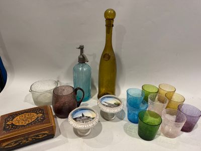 plusieurs verres de différentes couleurs et une bouteille sur la table