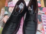 une paire de chaussures noires pour homme posée sur un magazine