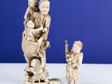 carved ivory figurines of a woman and child on a rock