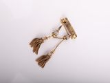 a close up of a pair of earrings with tassels on a white surface