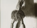 black and white photograph of a woman in a feathered dress holding a cell phone to her ear