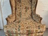 an old chair with a floral upholstered back