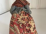 an old fashioned doll is sitting on a white surface