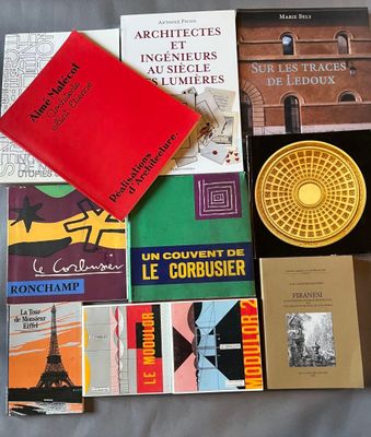 de nombreux livres posés sur un lit, avec une horloge en arrière-plan