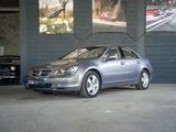 une voiture argentée garée dans un garage à côté d'une voiture noire