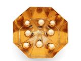 an image of a gold plate with pearls on it on a white background