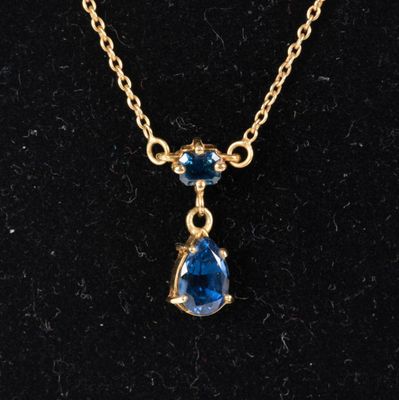 un collier en or orné d'une topaze bleue et d'une chaîne en or