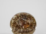 une image montrant un gros plan d'un objet en verre posé sur une surface blanche