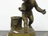 bronze figurine of a boy with a bucket on a marble base