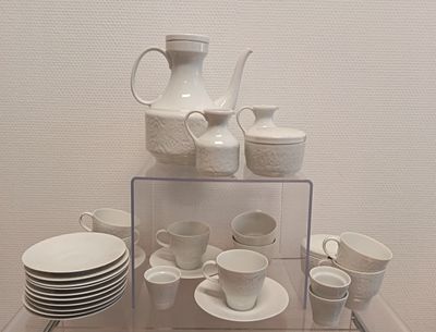 beaucoup d'assiettes et de tasses blanches posées sur une table en verre