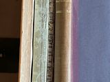 several old books are stacked on top of each other on a table