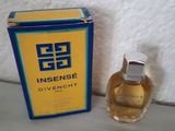 l'image d'un flacon de parfum posé à côté d'une boîte