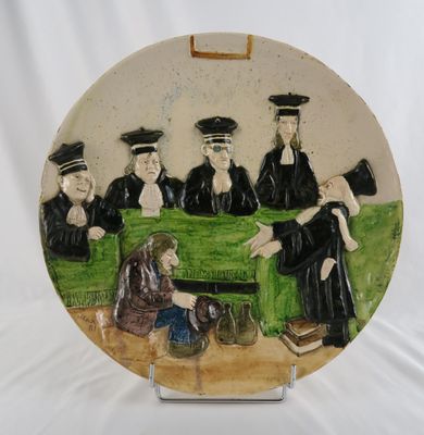 une assiette sur laquelle est représenté un groupe de personnes assises sur un banc