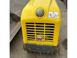a yellow tractor that is parked in the dirt
