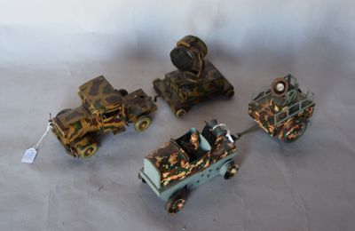 Plusieurs petits trains miniatures sont alignés sur une surface blanche