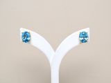 a close up of a pair of earrings on a white stand