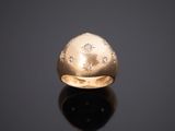 gros plan d'une bague en or avec des diamants sur une surface noire