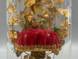 a glass clochet with a red cushion under it