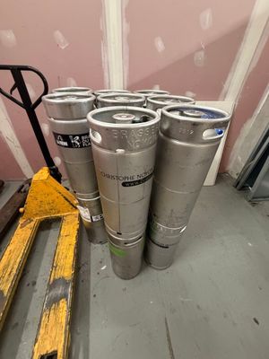 plusieurs fûts de bière posés sur une palette dans une pièce