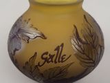 a yellow vase with a brown and white design on it