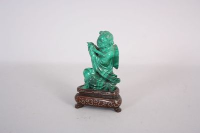 statue d'un homme assis sur un tabouret, tenant un livre