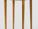 une petite table ronde avec un plateau et des pieds en bois