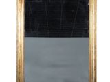 une image d'un miroir encadré d'or sur un mur blanc