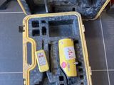 une mallette jaune contenant des outils, posée par terre à côté d'une boîte à outils