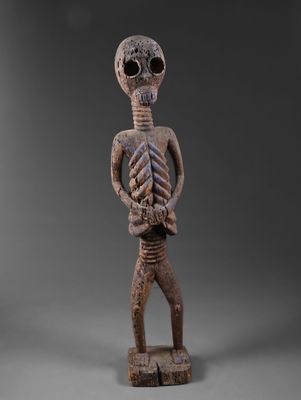 une figurine en bois représentant un squelette avec une tête et des bras de squelette