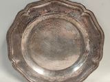 une assiette ancienne en argent sur fond blanc