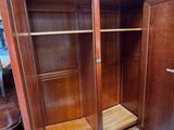 a wooden cabinet with a door open in a room