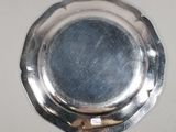 a silver plate with a small hole in the middle of it