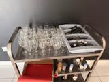 un chariot en métal sur lequel sont posés des verres à vin et d'autres objets