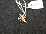 a gold necklace with a bird on it on a black surface