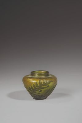 green glass vase on a white surface with a gray background