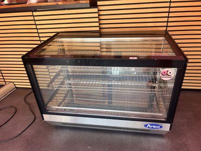 une vitrine en verre contenant beaucoup de nourriture