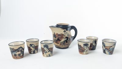 six cups and a pitcher sitting on a table